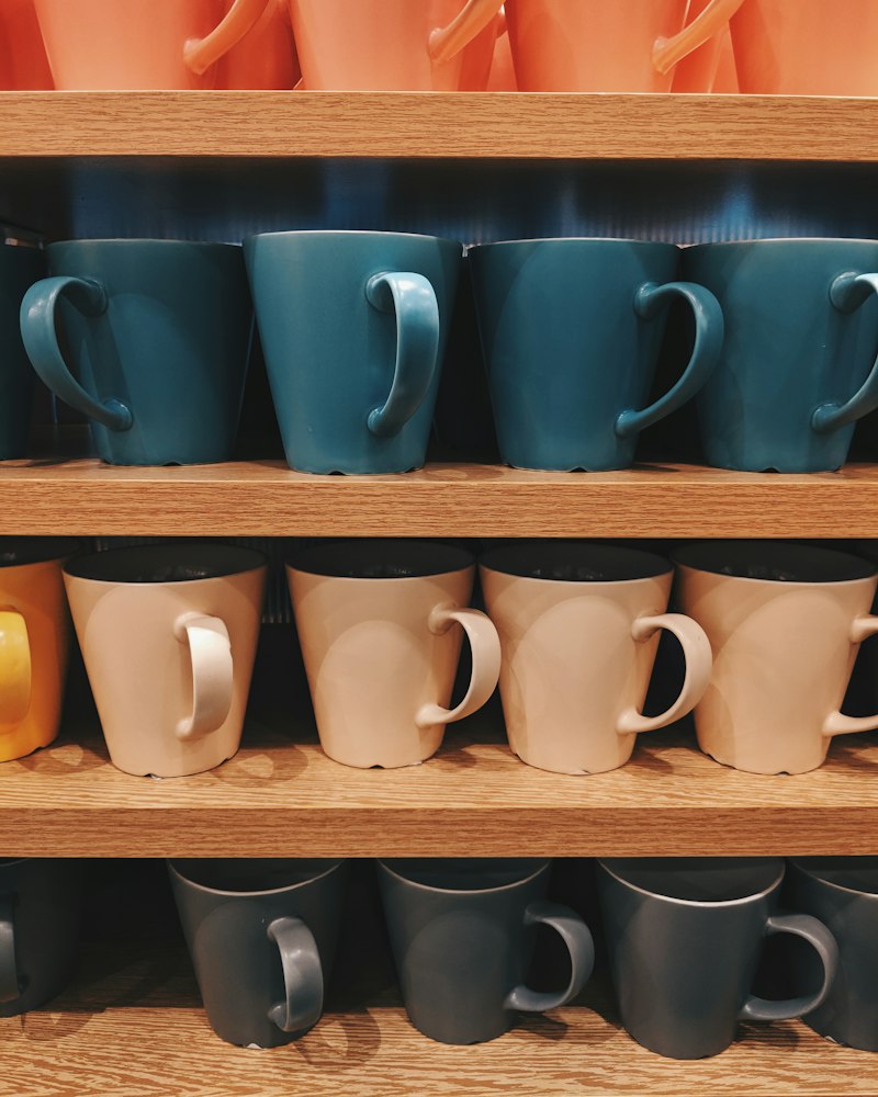 Ceramic mugs lined up on a shelf